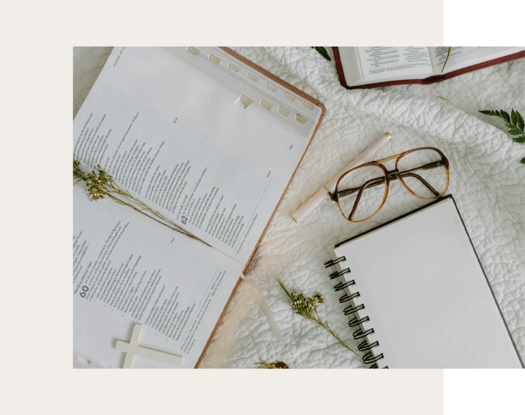 Open Bible with notebook and pen on a desk